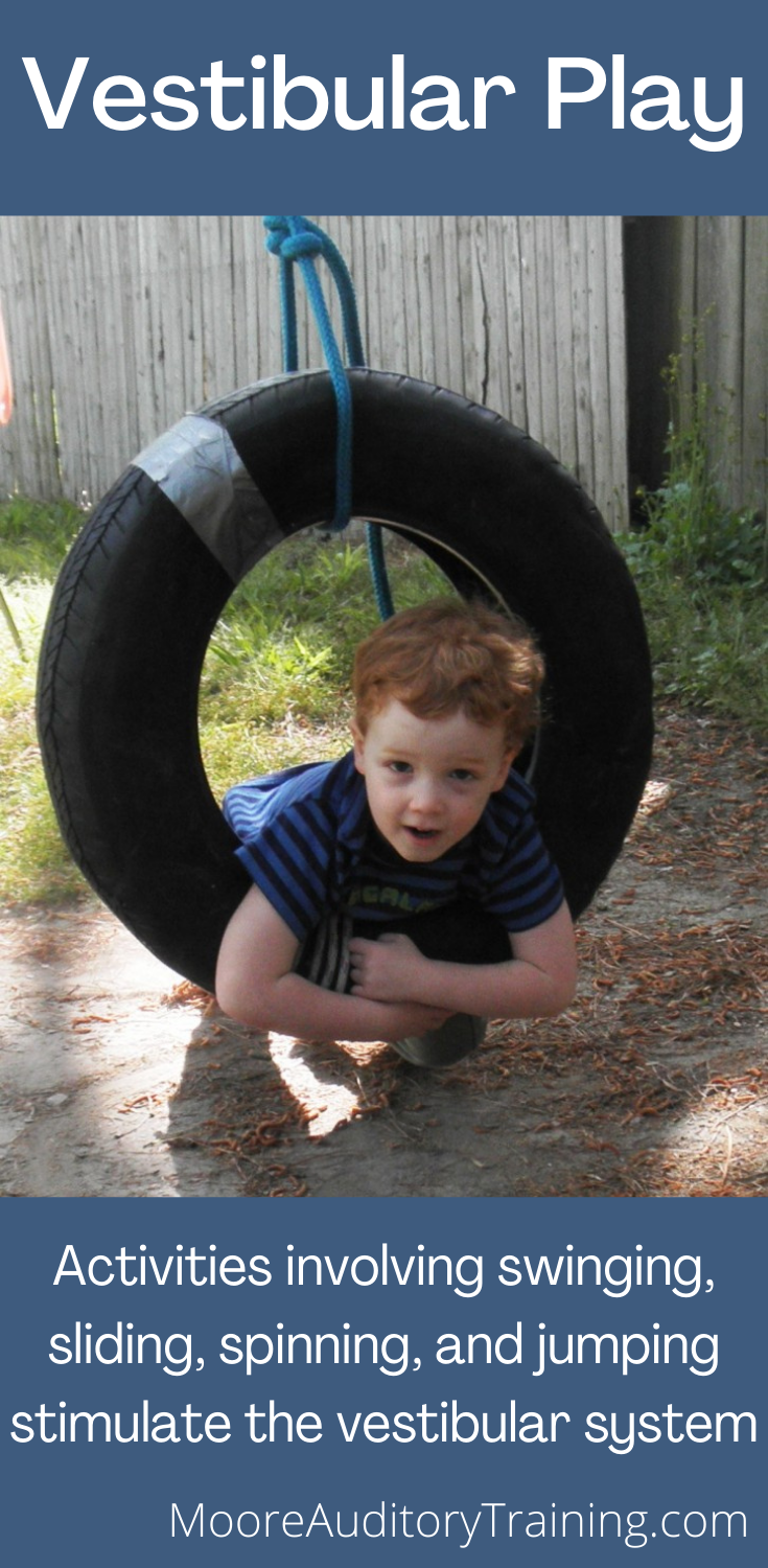 young boy on a tire swing