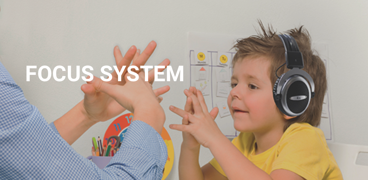 Young boy focusing on mirror hand play while listening to iLs Integrated Listening program. Improving Dyslexia and attention deficits are possible. 